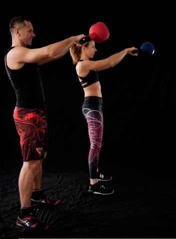 A man and a woman exercising with kettlebells